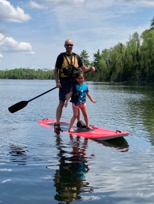 May paddle-boarding Dad on Jasper Lake at Northwind Lodge. Water is still cold!